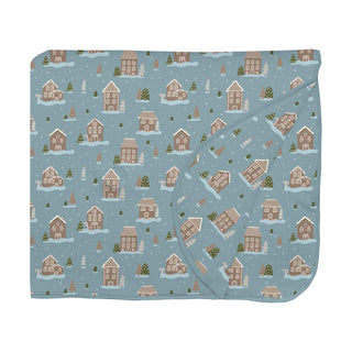 Folded blanket with a gingerbread winter village pattern on a blue background
