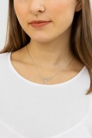 Star-shaped necklace worn by a person on a white background
