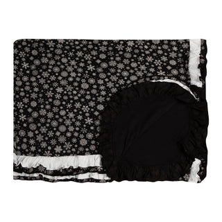 Black and white snowflake patterned blanket with ruffled edges on a white background