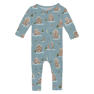 Baby onesie with a winter village pattern on a light blue background