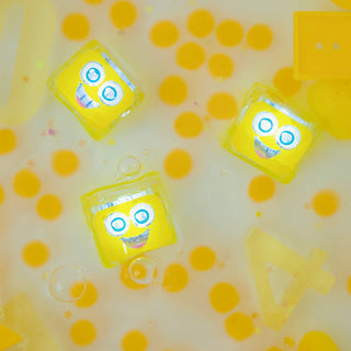 Water activated Yellow toy cubes with smiling faces floating in a yellow and white background