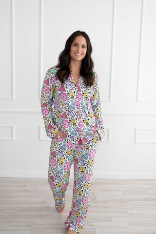 Woman wearing a colorful Def Leopard - Pour Some Sugar on Me inspired pajama set against a white wall.