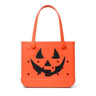 Orange Halloween-themed tote bag with a jack-o'-lantern face design on a white background